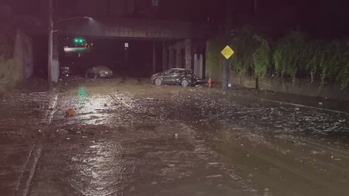 The aftermath of flooding on Ivanhoe Road at Euclid Avenue under the railroad bridge. Three cars were abandoned in the flood waters that accumulated under the bridge. The area is thick with mud and debris. No reported injuries