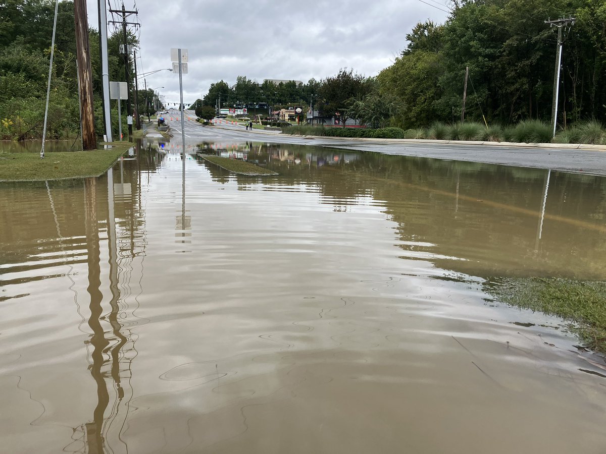 Flood water seeped into the roadway from Beaver Ruin Creek and blocked lanes of traffic on Indian Trail Road near I-85