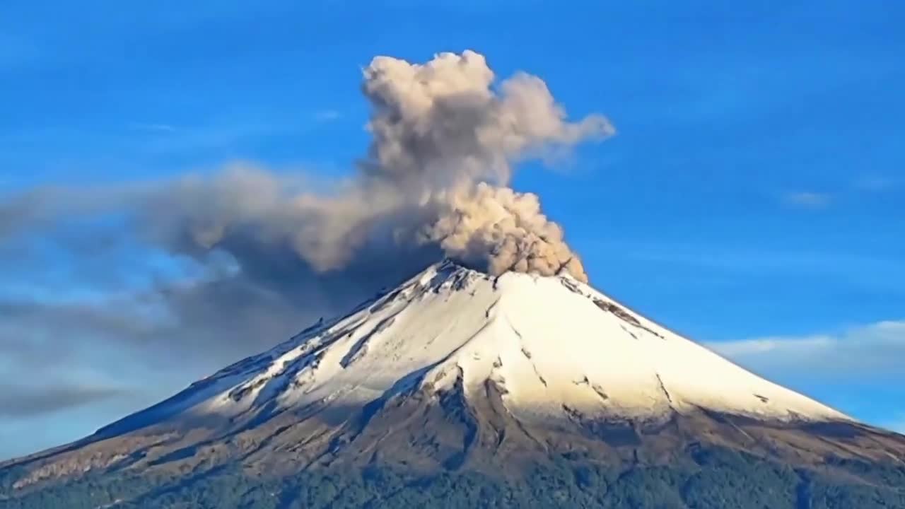 Popocatépetl volcano seen from Puebla, with tremendous fumarole and covered in snow