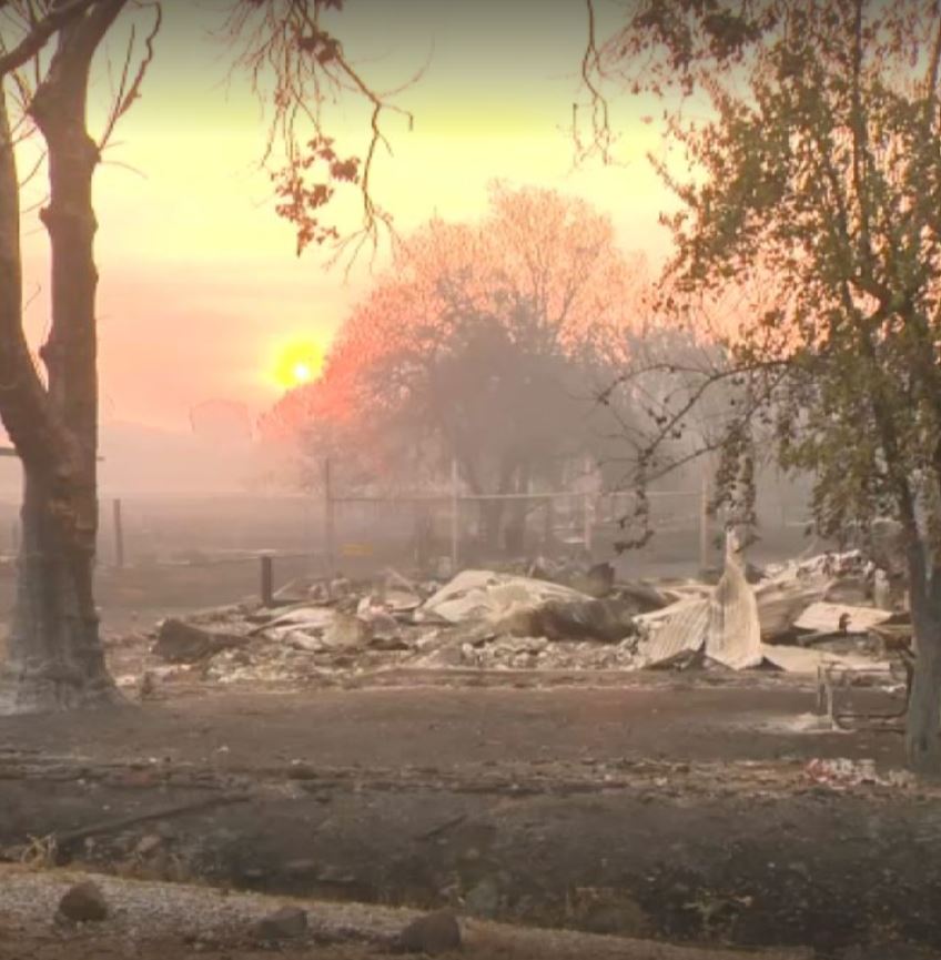 Sparked by lightning strikes, a wildfire in Northern California spreads to 12,000 acres with no containment, leveling several homes that comprised a historic gold-mining town.